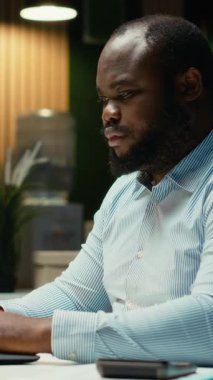 Dikey Video Dehası siyah erkek işçi saatler sonra yeni ve yenilikçi bir fikirle o anın kıvılcımını yakarak büyük bir buluş yapıyor. Parlak bir yaklaşımla aydınlanma ve yaratıcılık.