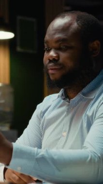 Akıllı telefondaki video konferansı sırasında personelle etkileşime giren Dikey Video İşadamı, bir brifing oturumu için son rapor verilerini paylaşıyor. İş çıkışı web sitesinde ortak toplantı. Kamera B.