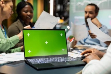 İş arkadaşları gece büroda yeşil ekranlı bir toplantı yapıyor, ekip üyeleri tahmin dosyalarını değiştiriyor ve proje hedefleri belirliyorlar. Hedef sunumları için performans özeti.