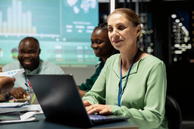 Bir gece toplantısında genel müdür, mali tahmin ve aylık güncellemeler için küresel pazar verilerini analiz eder, bir iş stratejisi oluşturur ve net hedefler belirler. Kadın lider..