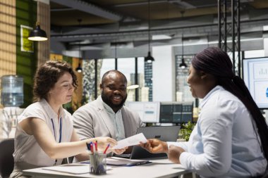 İş yerinde iş görüşmesi sırasında adaylarla CV değerlendirmesi yapan insan kaynakları ekibi, iş deneyimi ve kariyer geliştirme niteliklerini analiz etmektedir. Yetenek kazanma.