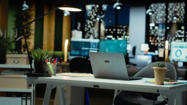 Modern boş ofis performans ölçümleri ve tahmin grafiklerinin ışığıyla parlıyor. Teknoloji ve bilgisayarlarla donatılmış şirket alanı işletme hedeflerinin yönetimini yansıtır.