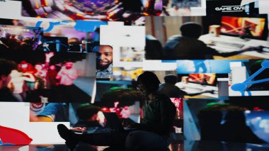 Genç bir kadın internette dizüstü bilgisayar kullanıyor, video yayınlarından içerik izliyor. Afro-Amerikalı gençler internetten VOD yayınlarını eğlendirmek için not defteri ve kamera A 'yı kullanıyorlar.