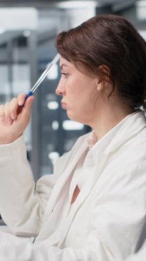 Dikey video Biyoteknoloji araştırmacısı PC kullanarak genetik işaretleyicileri değiştirerek hastalıkları nasıl önleyeceğini düşünüyor. Fikir üreten kadın, bilgisayardaki programla tıbbi araştırma yapan, kamera B