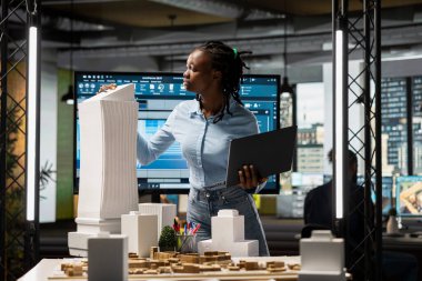 Siyahi kadın müteahhit imar yönetmeliğini 3D modellerle gözden geçiriyor, sürdürülebilir konut geliştirme için akıllı şehir altyapı büyümesi ile aynı hizada büyük bir planı olan konut projesi.