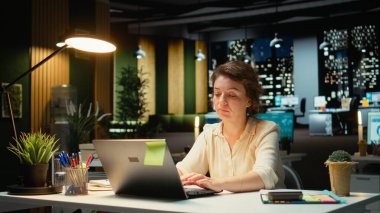 Gergin iş kadını, sırtı ve boyun kaslarını esnetiyor koltuk duruşunu ve boyun sertliğini düzeltiyor. Rahatsızlık ve yorgunluk. Kamera A.