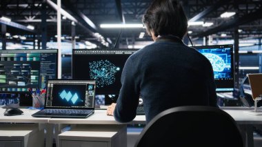 Yönetim veri merkezine giriyor, yapay zeka kontrollerini bilgisayarda gözden geçiriyor. IT uzmanı sunucu çiftliği masasında çalışmaya başlıyor, yapay zeka sistemleri yapılandırmasını optimize ediyor, kamera A