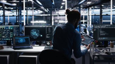 Veri merkezindeki cihazları kullanarak üretken yapay zeka yardımıyla kodlama yap. Bilgisayarda, laptopta ve tablette, kamera A 'da yapay zeka büyük dil modelleme teknolojisini denetleyen IT çalışanı.