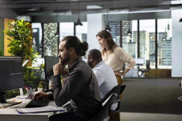 Şirket çalışma alanı koordinatlarında görev ve hedefleri belirleyen profesyonel bir erkek. Çalışan, şirket için ilerleme ve kaynak tahsisini sağlamak için dosyaları, projeleri ve iş istihbaratını gözden geçirir.