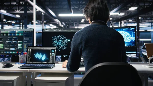 Yönetim veri merkezine giriyor, yapay zeka kontrollerini bilgisayarda gözden geçiriyor. IT uzmanı sunucu çiftliği masasında çalışmaya başlıyor, yapay zeka sistemleri yapılandırmasını optimize ediyor, kamera A