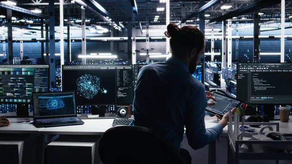 Veri merkezindeki cihazları kullanarak üretken yapay zeka yardımıyla kodlama yap. Bilgisayarda, laptopta ve tablette, kamera A 'da yapay zeka büyük dil modelleme teknolojisini denetleyen IT çalışanı.