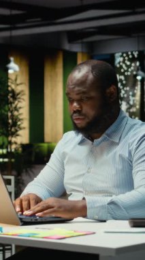 Dikey Video Hüsrana uğramış siyahi adam görev başarısızlığı ve patinaj yüzünden öfkeleniyor, gece geç saatlere kadar çalışıyor ve işyerinde zorluklarla karşılaşıyor. Erkek profesyonel duygular boğulmuş ve gerilmiş. Kamera A.