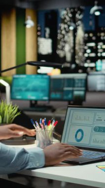 Dikey Video Erkek Ofisi çalışanı geceleri rakamları ve mali veri ölçümlerini kontrol ediyor, güncellemeleri belgeliyor ve yaklaşan iş etkinliklerinin gündemini düzenliyor. İdari görevler. Kamera A.