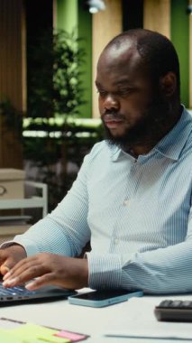 Dikey video çok çalışan erkek çalışanı randevulaşmadan önce takvimi kontrol ediyor, akıllı telefonunu kaldırıp mesajlara cevap veriyor ve bildirimleri okuyor. İnsanın dikkati dağılıyor ve kaşlarını çatıyor. Kamera A