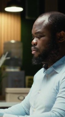 Dikey Video Siyah Adam danışmanı, gece geç saatlere kadar uyanık kalmak için bir fincan kahvenin tadını çıkarıyor. Şirket alanındaki idari işlerle uğraşıyor. Geceleri kafein içeceğiyle düzeltme ve yazma