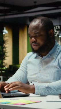 Dikey Video Afrikalı Amerikalı adam, karanlık bir ofiste saatlerce çalışan çok uluslu bir şirket için çevrimiçi görüşlerden gelen e-postaları cevaplıyor ve verileri belgeliyor. Girişim hedefleri ve gelişimi