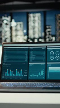 Dikey Video Boş İş Alanı gece yarısı veri raporları ve analitikler sergilenirken, şehir ışıkları şirket yönetim kurulunda. Yönetim için finansal projeksiyonları olan modern çalışma alanı.