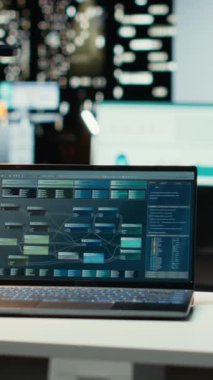 Gece geç saatlerde boş karanlık bir ofiste, bir çalışma istasyonunda dikey video dizüstü bilgisayar, gelecekteki raporlar için veri ve bilgi içeriyor. Performans ölçümleri ve öngörü grafikleri işi yansıtır