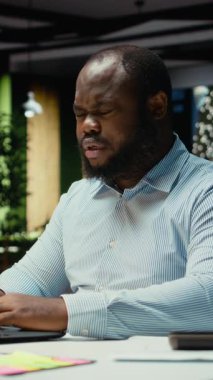 Dikey video, gece geç saatlerde zihinsel yorgunluk ve rahatsızlıkla boğuşan sorunlu personelin yoğun iş yükü ve sağlıksız yaşam tarzı belirtileri gösteriyor. Endişeden bunalmış bir adam. Kamera.