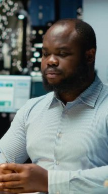 Dikey Video Siyah iş danışmanı mesai bitiminden sonra online bir video görüşmesine katılıyor, hissedarlarla internet üzerinden görüşmelerine katılıyor. Profesyonel adam ağ kurma oturumunda insanlarla iletişim kuruyor