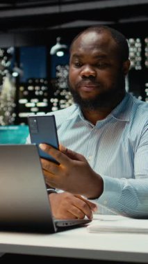 Akıllı telefondaki video konferansı sırasında personelle etkileşime giren Dikey Video İşadamı, bir brifing oturumu için son rapor verilerini paylaşıyor. İş çıkışı web sitesinde ortak toplantı. Kamera A.