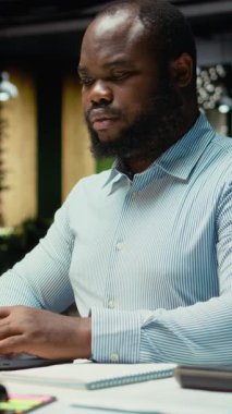 Dikey Video Afrikalı Amerikalı çalışan, gece geç saatlerde ofiste bir özet hazırlıyor ve güncelleme yapıyor. Veriler, aylık faaliyet planlayıcısı, iş hedefleri ve gündemi ile bilgi rapor etmektedir