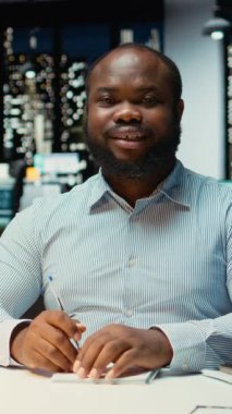 Dikey Video Afrikalı Amerikalı erkek danışman dizüstü bilgisayardaki bir video görüşmesine katılıyor, mesai saatleri dışında tartışılıyor. Profesyonel adam hissedarlarla etkileşim içinde, ağ oluşturma oturumunda uyumluluk