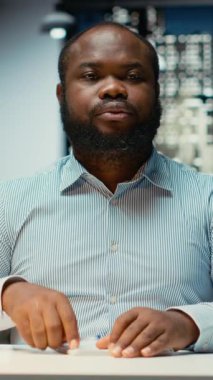 Yatırımcı grupla telekonferans görüşmesi yapan Dikey Video Siyah Erkek CEO ofis masasından yapılan uzak bir telefon görüşmesine katılıyor. Personel ağları, yönetim kuruluyla görüşmeler.