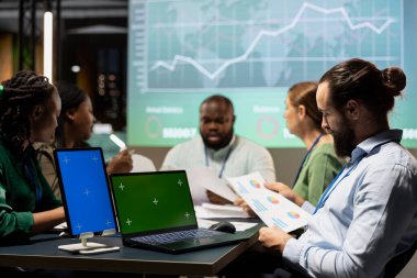 Çeşitli uzmanlar, proje geliştirme için finans hedeflerini sıralayarak, saatler sonra izole edilmiş bir şirket etkinliği için bir araya geliyorlar. Gecenin geç saatlerinde yapılacak sunuma hazırlanıyorum..