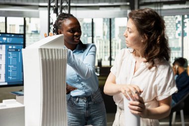 Üç boyutlu model ve araçlarla imar düzenlemelerini inceleyen kadın mühendisler, altyapı büyümesi için yapısal planlarla alan hazırlıkları yapıyorlar. Modern konut projesi.