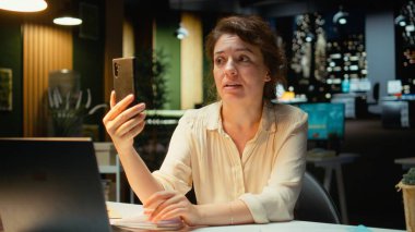 Girişimci, telefonuyla çalıştığı istasyonda ekrandaki tartışmaya odaklanmış sanal bir brifinge katılıyor. Dikkatle dinlemek, takım çalışması ve ortaklık için fikir alışverişinde bulunmak. Kamera A.