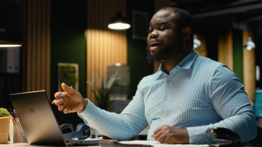 Siyah erkek avukat gece geç saatlerde internet üzerinden video çağrısına cevap veriyor, yeni proje için verileri bildiriyor ve şeffaf bir tartışmaya girişiyor. İlişkileri güçlendirmek için fikir alışverişi.