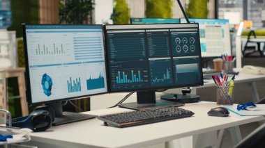 Boş şirket ofisinde yüksek teknoloji ve çift monitörler, iş stratejisi ve rapor yazma için hazır analitik araçlar bulunuyor. Profesyonel büyüme ve örgütsel başarı.