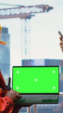 Askeri telsiz aracılığıyla iletişim kuran askerler tarafından kullanılan dikey krom anahtar dizüstü bilgisayar. Deniz kuvvetleri mavnayı delmek için yeşil ekran model not defteri kullanıyor, telsizle konuşuyor.