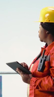 Offshore platform meslektaşları, güvenlik protokollerine uymalarını sağlayarak, güverte operasyonlarını cihazlarla denetliyor. Ekip ekipmanları kontrol ediyor sondaj kulesi, kamera B