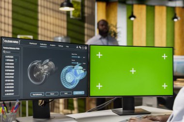CAD tasarımcısı, türbini yükseltmek ve karbon ayak izini azaltmak için ofisteki yeşil ekran modelleme bilgisayarını kullanıyor. Verimliliği optimize etmek için krom anahtar PC üzerindeki eko türbin sensör verilerini uzman incelemeleri