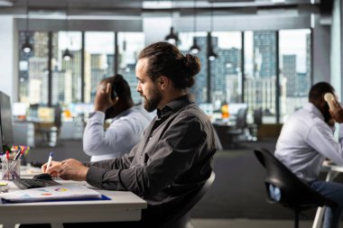 Çalışma masasında finans ve bütçe yönetimi, veri arşivleri ve kalkınma projeleri konularında danışmanlık. Hedeflere ulaşmak için belge, diyagram ve raporları analiz eden personel.