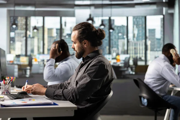 Çalışma masasında finans ve bütçe yönetimi, veri arşivleri ve kalkınma projeleri konularında danışmanlık. Hedeflere ulaşmak için belge, diyagram ve raporları analiz eden personel.
