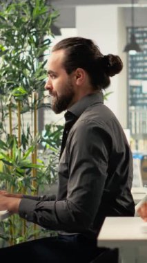 Dikey Video İşadamları dizüstü bilgisayarların etrafında toplanarak proje görevleri ve geliştirme hedefleri üzerinde çalıştılar. Ofis ortamı, analiz ve planlama yoluyla sinerji, takım çalışması ve içgörüyü teşvik eder