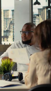 Dikey Video Çalışmaları ekibi iş toplantısı sırasında müzakere ve proje danışmanlığı ile meşgul oldu. Çalışanlar karanlık bir ofis ortamında finans verilerini, ölçümlerini ve performans raporlarını analiz etmek için dizüstü bilgisayar kullanırlar