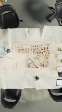 Vertical Video Top, iş toplantısındaki geliştirici ve mimarlara zoom yaparak projeleri ve yapısal tasarımları gözden geçiriyor. Takım, konut büyümesi için yeniden yapılanma ve şehir planlamasını tartışıyor