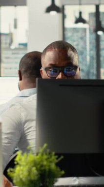 Ofisteki dikey video çeşitliliği çalışanları analitik ve tahminler üzerinde çalışıyor. Profesyonel personel yönetimi ve iş hedeflerini geliştirmek için görsel verileri, diyagramları ve belgeleri gözden geçirir