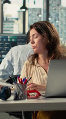 Yönetim kurulundaki rapor paylaşım oturumunda iş verilerini ve ölçümleri analiz eden dikey video çeşitliliği grubu. Profesyonel çalışma ekibi tahminleri ve yönetim kavrayışlarını tartışıyor