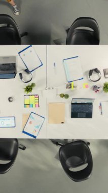 Toplantıdan önce iş adamlarının birbirlerini selamladıklarını düşey video tepesinde görüyoruz, iş arkadaşları bütçe ve proje geliştirme konularını tartışıyor. Çeşitli çalışma ekibi dizüstü bilgisayardaki raporları ve verileri gözden geçiriyor