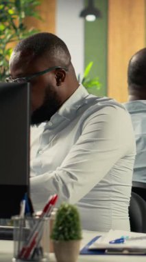 Dikey Video Şirketi çalışanları hedef ve hedefleri belirlemek için idari yönetimle buluşuyor. Haritalar, şemalar ve raporlar pazar araştırmaları için ilerleme ve iş istihbaratını vurguluyor. Kamera B.