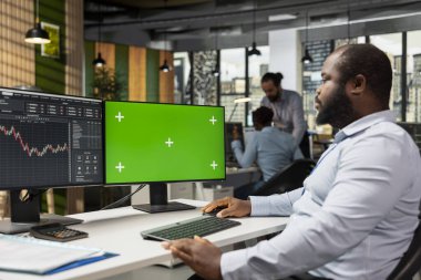 Prodüksiyon şirketinin iş arkadaşları hisse senedi verilerini analiz etmek için yeşil ekran modelleme bilgisayarı kullanıyorlar. Aracı şirket ekibi izole ekran kroma anahtar bilgisayarı kullanarak borsa trendlerini belgeliyor