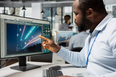 Mühendisler şanzıman kulesi sistemlerini rafine ediyor, verimliliği artırıyor ve yenilenebilir enerji entegrasyonunu destekliyor. Ofisteki Afrikalı Amerikalı adam eko elektrik hatlarının altyapısını tasarladı