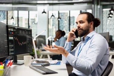 Ofisteki mali danışman akıllı telefon kullanıyor, müşterilerle telefonda yatırım stratejileri geliştirmek için konuşuyor. Danışman müşterilerle sohbet etmek, hizmet sağlamak için cep telefonu kullanıyor