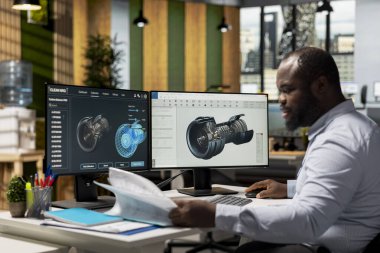 Ofisteki teknisyen alternatif enerji verimliliğini arttırmak için rüzgar türbini bileşeni belgelerini okuyor. Türbin dizaynını rafine etmek için evrakları inceleyen araştırmacı