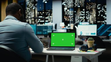 Siyah erkek işçi geceleri bilgisayardaki krom anahtar ekrana bakar, mesai saatleri dışında iş işlerini halleder. Proje geliştirme, hedeflere ulaşma ve hedefler üzerinde çalışan ofis danışmanı.